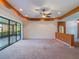 Expansive living room with access to a screened lanai through sliding glass doors, featuring neutral carpet at 27307 Pine Straw Rd, Leesburg, FL 34748