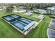Aerial view of community tennis courts and bocce ball courts surrounded by green space at 27307 Pine Straw Rd, Leesburg, FL 34748