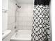 Tiled bathtub and shower with black and white shower curtain in a bathroom at 3057 Aaron Burr Ave # 1, Winter Park, FL 32792