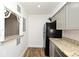 View of the kitchen featuring granite countertops, gray cabinets, and a black refrigerator at 3057 Aaron Burr Ave # 1, Winter Park, FL 32792