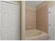 Bathroom featuring a tiled bathtub, a closet, and a door at 326 Cotswold Cir, Davenport, FL 33837