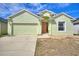 Inviting one-story home with a two-car garage, manicured lawn, and a light green exterior at 326 Cotswold Cir, Davenport, FL 33837
