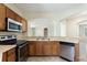 Practical kitchen featuring wooden cabinets, stainless steel appliances, and an open layout at 326 Cotswold Cir, Davenport, FL 33837