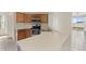 Well-lit kitchen with wooden cabinets, stainless steel appliances, and an adjacent breakfast bar at 326 Cotswold Cir, Davenport, FL 33837