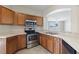 Well-equipped kitchen featuring wooden cabinets, stainless steel appliances, and tiled flooring at 326 Cotswold Cir, Davenport, FL 33837