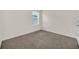 This bedroom is vacant and shows a large carpeted area and a bright window at 3308 Country Walk Club Cir, Winter Haven, FL 33881