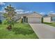 Charming single Gathering home featuring a well-manicured lawn, neutral color palette, and an attached two car garage at 3308 Country Walk Club Cir, Winter Haven, FL 33881