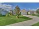 A well-maintained single-Gathering home in a residential neighborhood featuring lush grass and mature landscaping at 3308 Country Walk Club Cir, Winter Haven, FL 33881