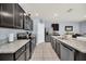 Modern kitchen with black appliances, granite countertops, tile flooring, and ample cabinet space at 3308 Country Walk Club Cir, Winter Haven, FL 33881