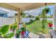 Relaxing covered patio filled with lush green plants, a glass table and backyard views at 3308 Country Walk Club Cir, Winter Haven, FL 33881