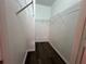 A walk-in closet with multiple wire shelves and dark wood-look floors for ample storage at 3332 Robert Trent Jones Dr # 10703, Orlando, FL 32835