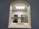 Arched opening showing view of the kitchen with stainless steel appliances and white cabinets at 3332 Robert Trent Jones Dr # 10703, Orlando, FL 32835
