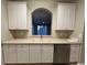 Kitchen view from the arched opening, featuring white cabinets and stainless steel appliances at 3332 Robert Trent Jones Dr # 10703, Orlando, FL 32835
