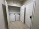 The laundry room features a side by side washer and dryer, tile flooring and a storage shelf at 3332 Robert Trent Jones Dr # 10703, Orlando, FL 32835