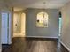 Spacious living room leads to the kitchen area with a view of the modern light fixture above at 3332 Robert Trent Jones Dr # 10703, Orlando, FL 32835