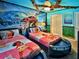 Fun, vibrantly colored Moana themed bedroom with two beds, blue walls, and themed accents at 3356 Lilac Way, Davenport, FL 33897