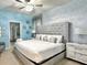 Bright bedroom featuring a king bed with a padded headboard, snowflake accents, and ensuite at 3356 Lilac Way, Davenport, FL 33897