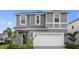 Charming gray two-story home featuring a well-maintained lawn and inviting curb appeal at 3356 Lilac Way, Davenport, FL 33897