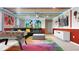 Spacious recreation room with vibrant Mickey Mouse theming, a comfortable sofa and a foosball table at 3356 Lilac Way, Davenport, FL 33897