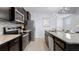 Modern kitchen with stainless steel appliances, granite countertops, and sleek dark wood cabinetry at 3356 Lilac Way, Davenport, FL 33897