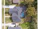 Aerial view of a gray roof house, a screened-in pool, mature landscaping, plus driveway and lawns at 358 Woldunn Cir, Lake Mary, FL 32746