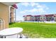 Condo lawn area featuring a swimming pool, building, outdoor seating, and well-manicured green grass at 3801 S Atlantic Ave # 105, New Smyrna Beach, FL 32169