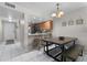 View of kitchen, dining area and entry featuring white tiled floors and natural light at 3801 S Atlantic Ave # 105, New Smyrna Beach, FL 32169