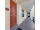 Condo with a vibrant orange entrance door and welcoming neutral hallway to all units at 3801 S Atlantic Ave # 105, New Smyrna Beach, FL 32169