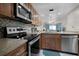 Kitchen featuring granite countertops, stainless steel appliances, wooden cabinets, and open to the living area at 3801 S Atlantic Ave # 105, New Smyrna Beach, FL 32169