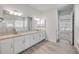 Bathroom featuring double sinks, granite countertop, large mirror, and a walk-in shower at 388 Nowell Loop, Deland, FL 32724