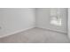 A well-lit bedroom features neutral carpet, trim, and walls, complete with a bright window at 388 Nowell Loop, Deland, FL 32724
