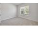 A well-lit bedroom features neutral carpet, trim, and walls, and a bright window at 388 Nowell Loop, Deland, FL 32724