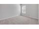 Empty bedroom featuring plush carpet, base molding, and a sunlit window at 388 Nowell Loop, Deland, FL 32724