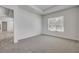 An empty bedroom featuring plush carpet, tray ceiling, and a sunlit window at 388 Nowell Loop, Deland, FL 32724