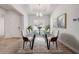 Bright dining room features modern table set with art, chandelier, trey ceiling and wood look flooring at 388 Nowell Loop, Deland, FL 32724