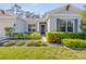 Inviting single-story home with a dark front door, lush lawn, and vibrant landscaping, creating a warm entrance at 388 Nowell Loop, Deland, FL 32724