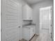 This laundry room features cabinets, granite counters, and wood look tile at 388 Nowell Loop, Deland, FL 32724