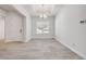 Open living room has neutral walls, tray ceiling, modern chandelier and beautiful tile flooring at 388 Nowell Loop, Deland, FL 32724