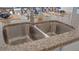 Close-up of a modern stainless steel kitchen sink with granite countertops at 3881 Diving Dove Ln, Bartow, FL 33830