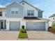 Exterior of townhome showing blue and white paint, gray garage doors, and driveway at 3908 Grassland Dr, Orlando, FL 32824