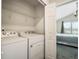 Laundry room with white washer and dryer and wire rack shelf at 3908 Grassland Dr, Orlando, FL 32824
