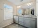 Main bathroom featuring double vanity, ample cabinet space, and a window for natural light at 3908 Grassland Dr, Orlando, FL 32824