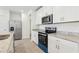 Modern kitchen features stainless steel appliances, granite countertops, and white cabinets at 4365 Switchgrass Ln, St Cloud, FL 34772