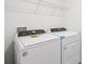 Laundry room featuring a Whirlpool washer and dryer with white wire shelves at 4365 Switchgrass Ln, St Cloud, FL 34772