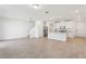 Spacious open-concept living area with tile flooring, stairs and view of the modern kitchen at 4365 Switchgrass Ln, St Cloud, FL 34772