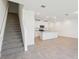 Open-concept living area featuring tile floors, staircase, and a kitchen with granite countertops at 4365 Switchgrass Ln, St Cloud, FL 34772