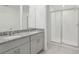 Modern bathroom featuring double vanity with granite counters and a glass enclosed shower at 4369 Switchgrass Ln, St Cloud, FL 34772