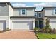 Attractive townhome featuring brick driveway, attached garage, manicured lawn, and pleasant facade at 4369 Switchgrass Ln, St Cloud, FL 34772