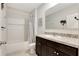 Bathroom featuring a tub and shower combo, granite counters, and dark cabinets offering functionality at 512 Stowers Dr, New Smyrna Beach, FL 32168