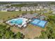 Aerial view of a community pool, clubhouse and sports courts in a residential area at 512 Stowers Dr, New Smyrna Beach, FL 32168